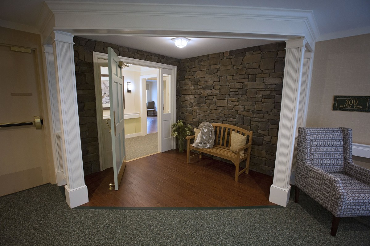 Cozy entrance with a stone wall and wooden bench.