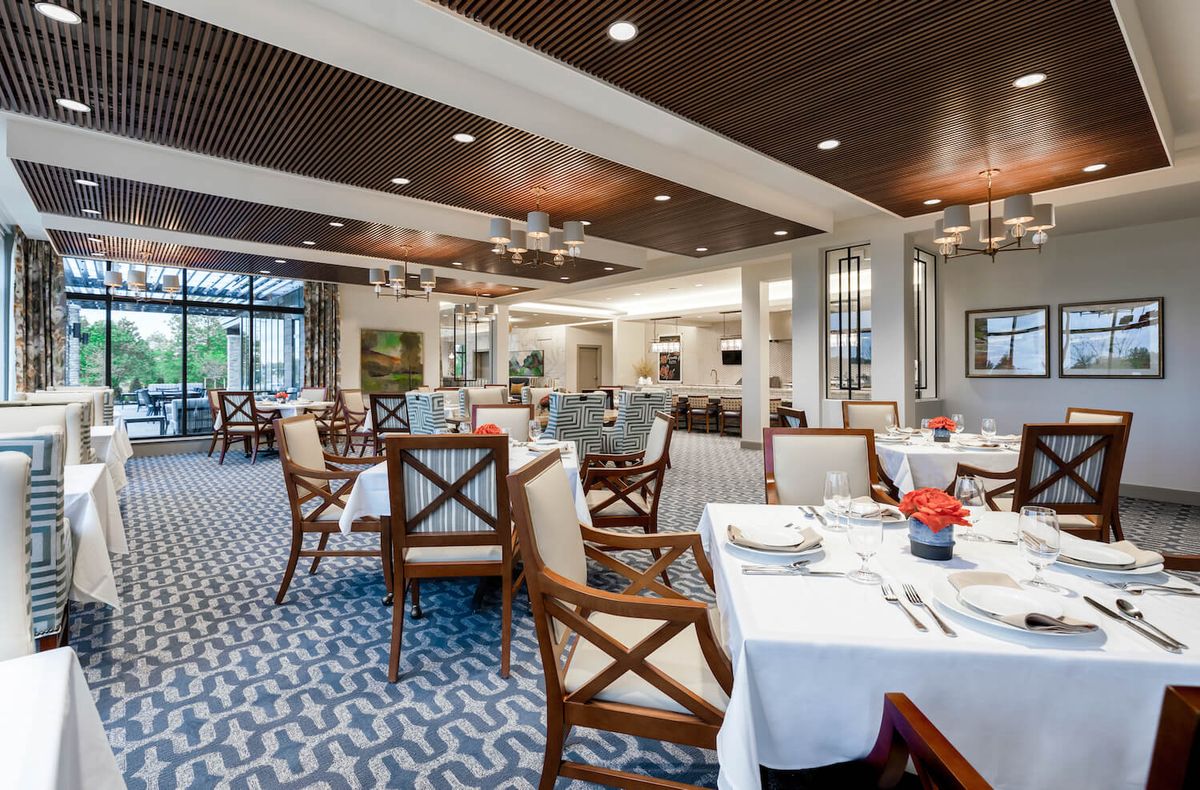 An elegant restaurant dining room with neatly arranged tables and chairs.