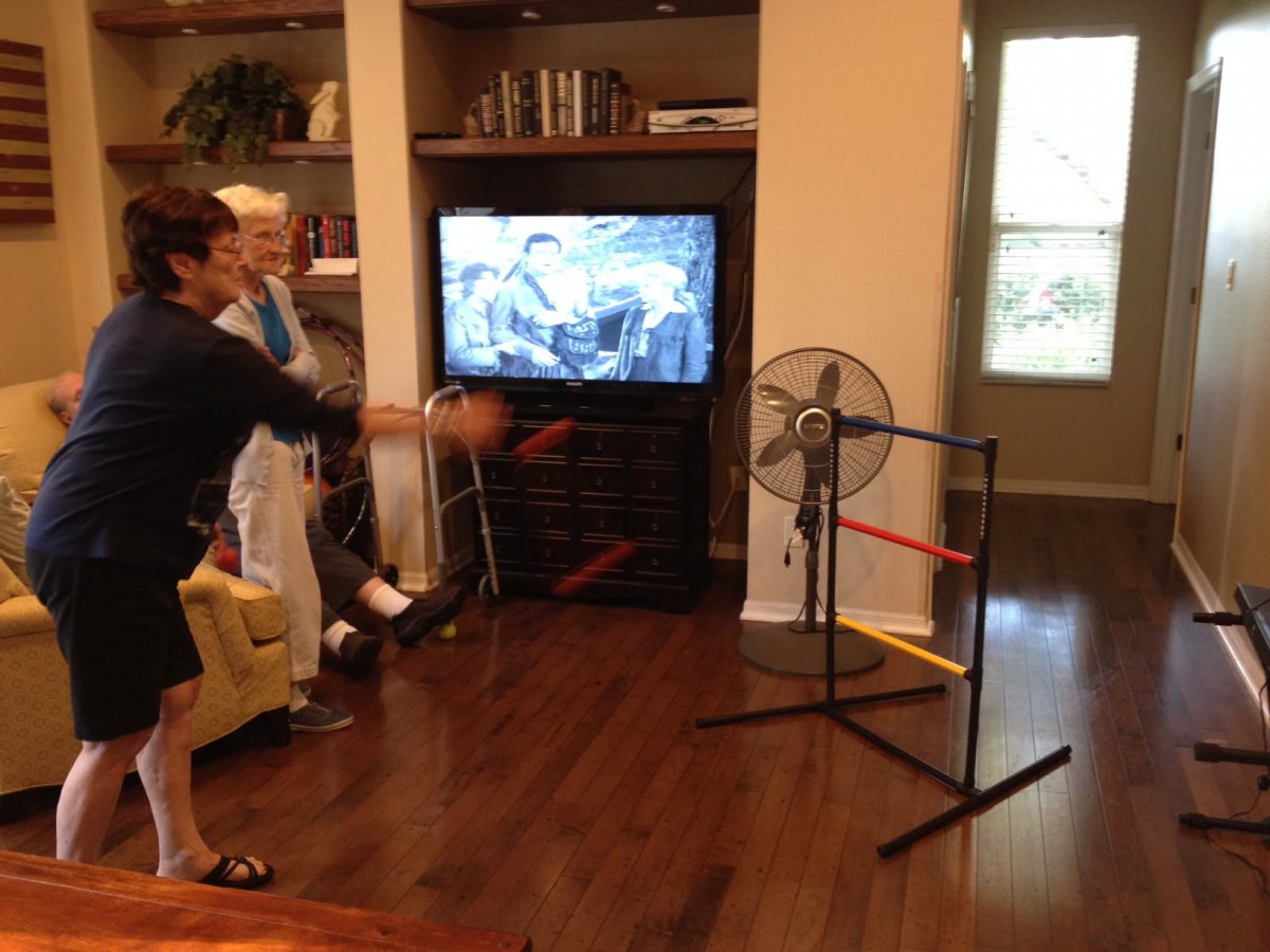 Family playing an indoor game of ladder toss in the living room.