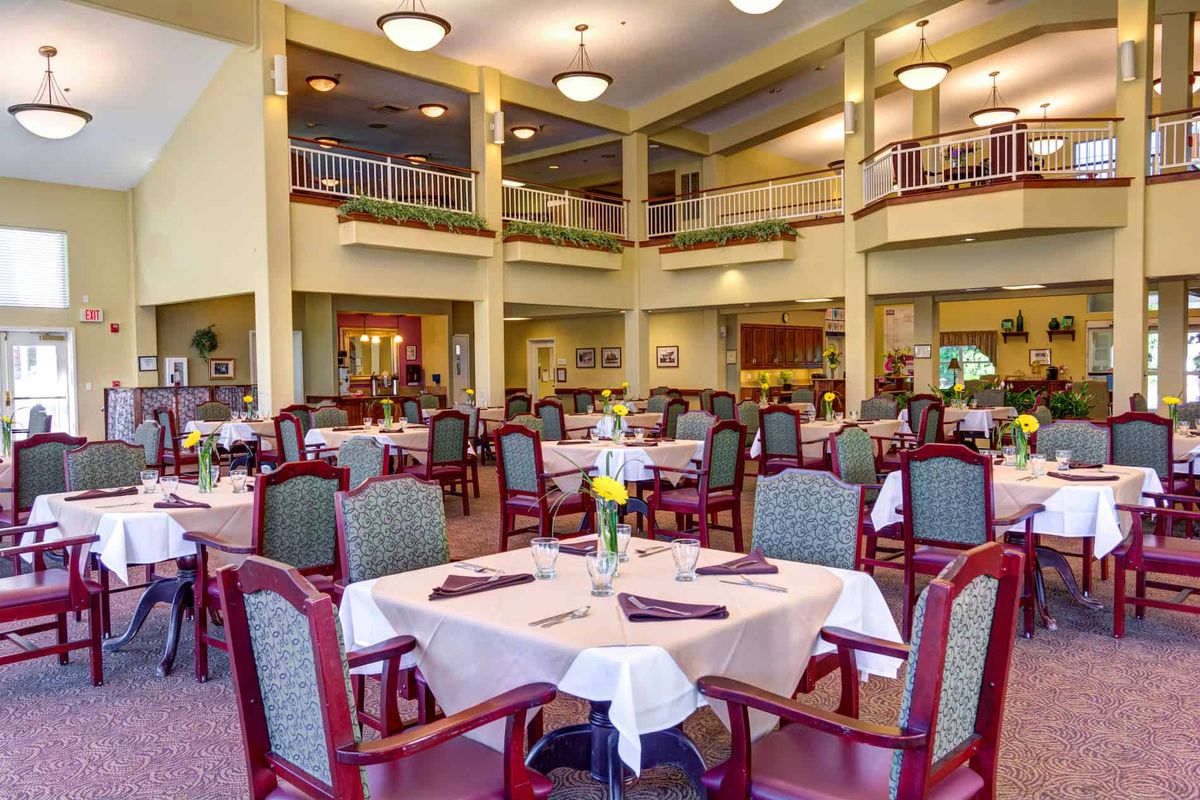 A spacious and elegantly decorated dining area with neatly arranged tables and chairs.