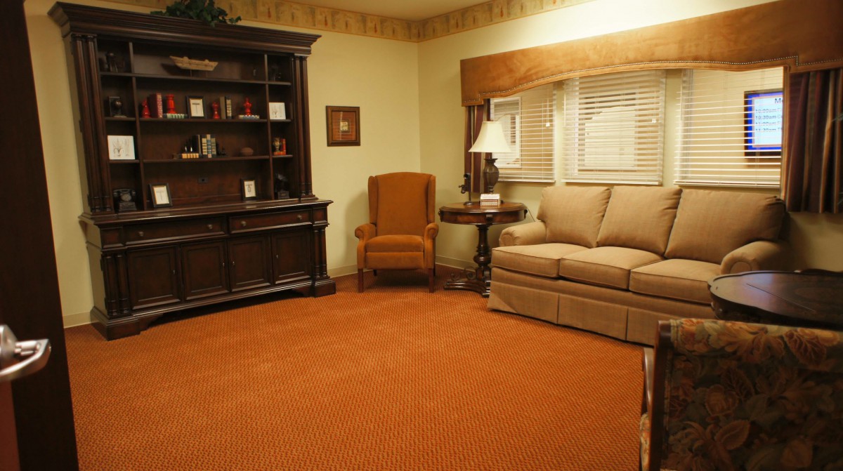 A cozy living room with a sofa, armchair, and bookshelf.