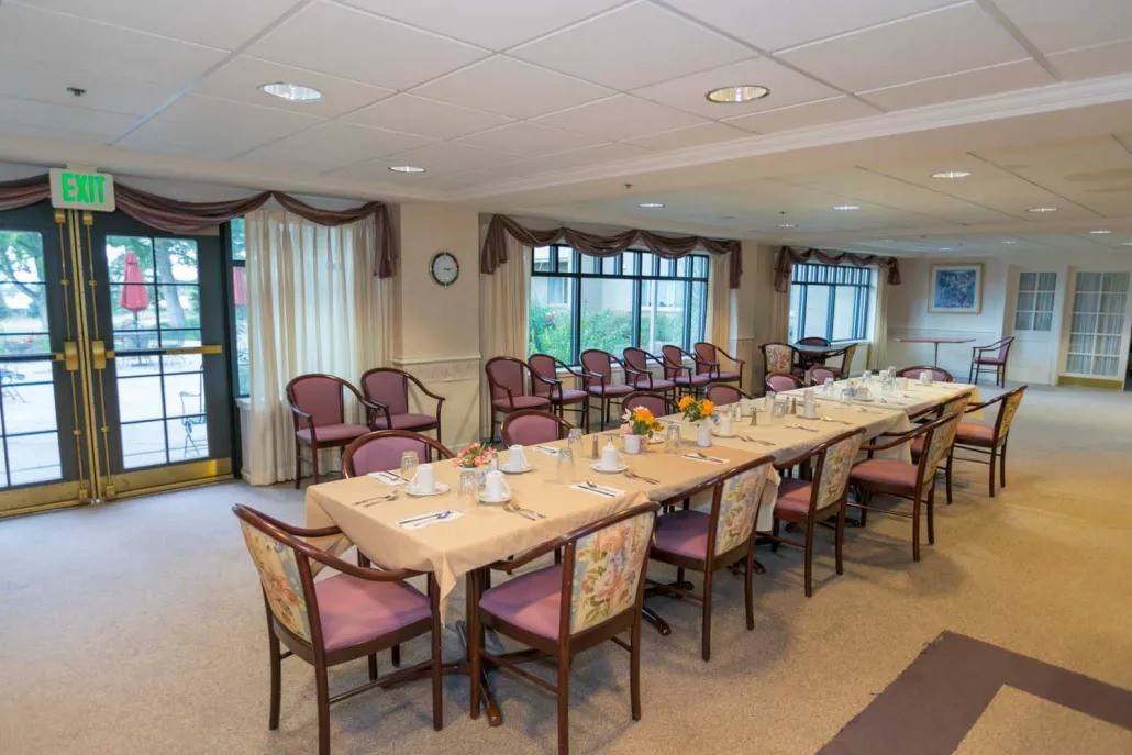 A formal conference room set up with a long meeting table and multiple chairs.