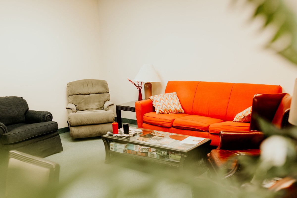 A cozy living room with an orange sofa and armchairs.