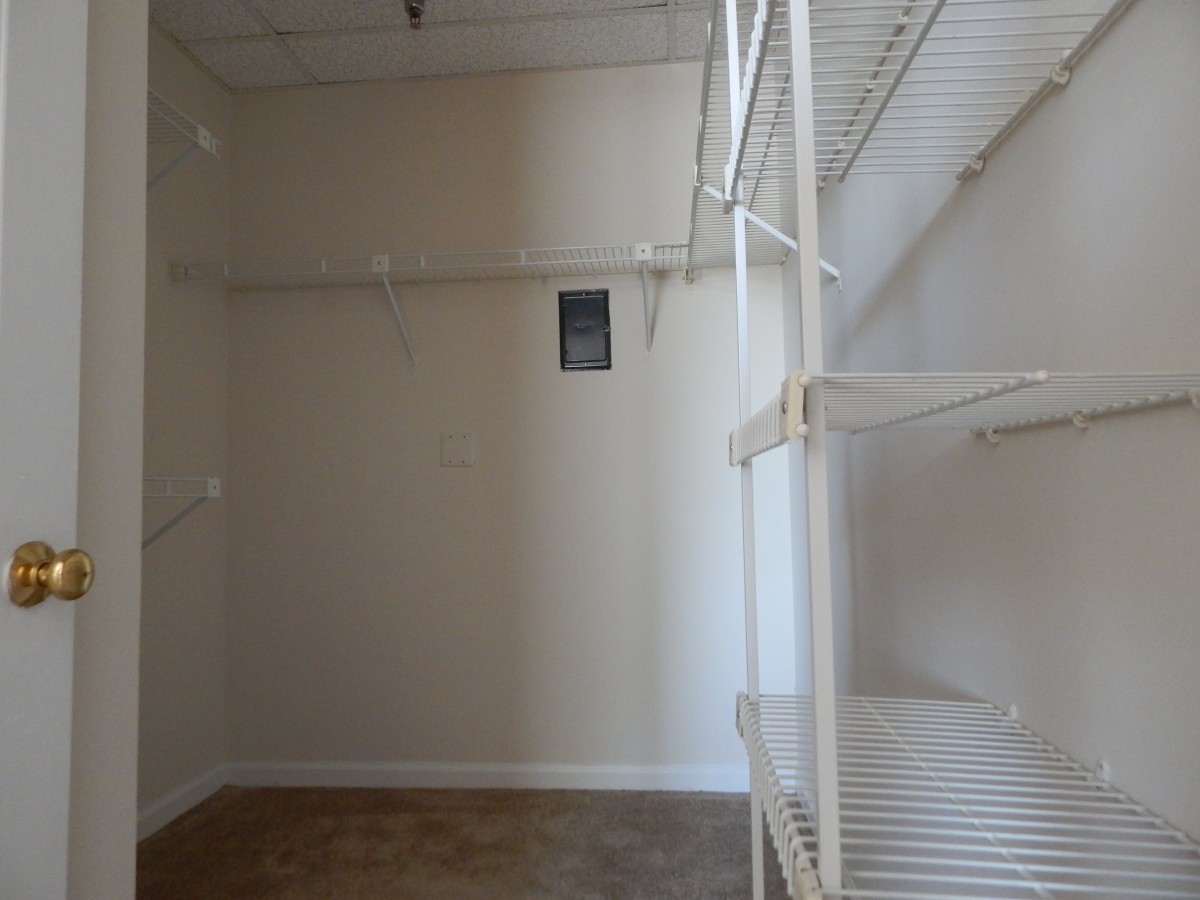 An empty closet with wire shelving and a hardwood floor.