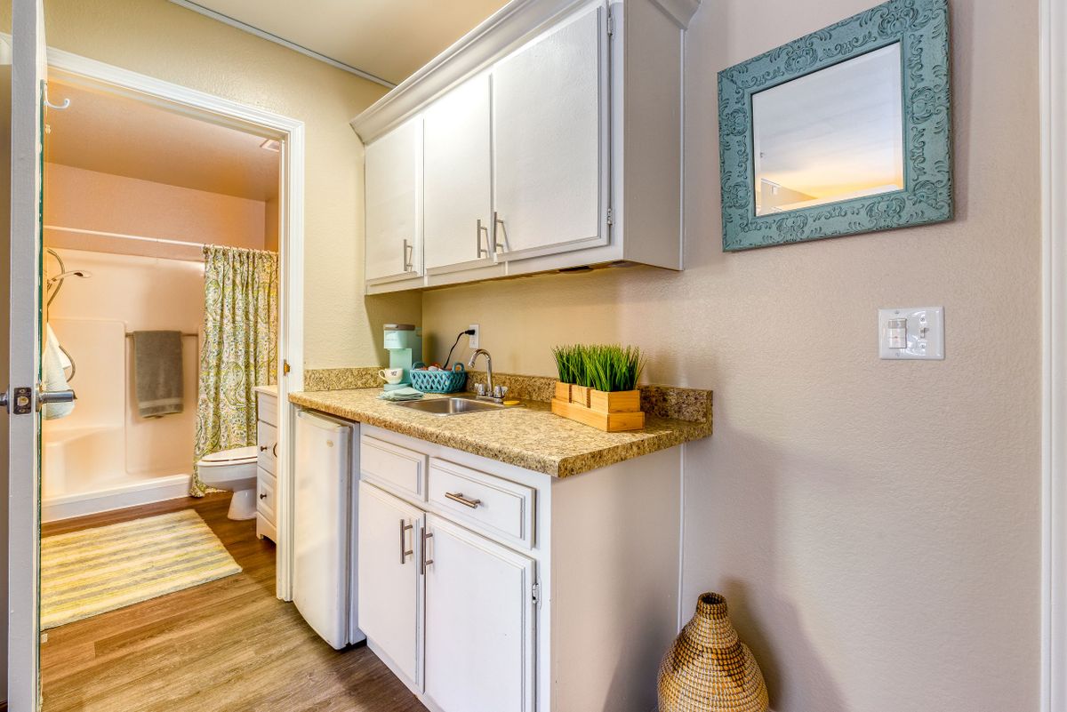 A beautifully designed kitchen with white cabinets, wooden countertops, and decorative elements.
