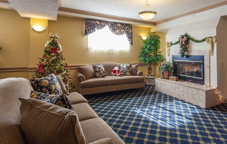 A cozy living room decorated for Christmas with a tree, sofa, and festive ornaments.