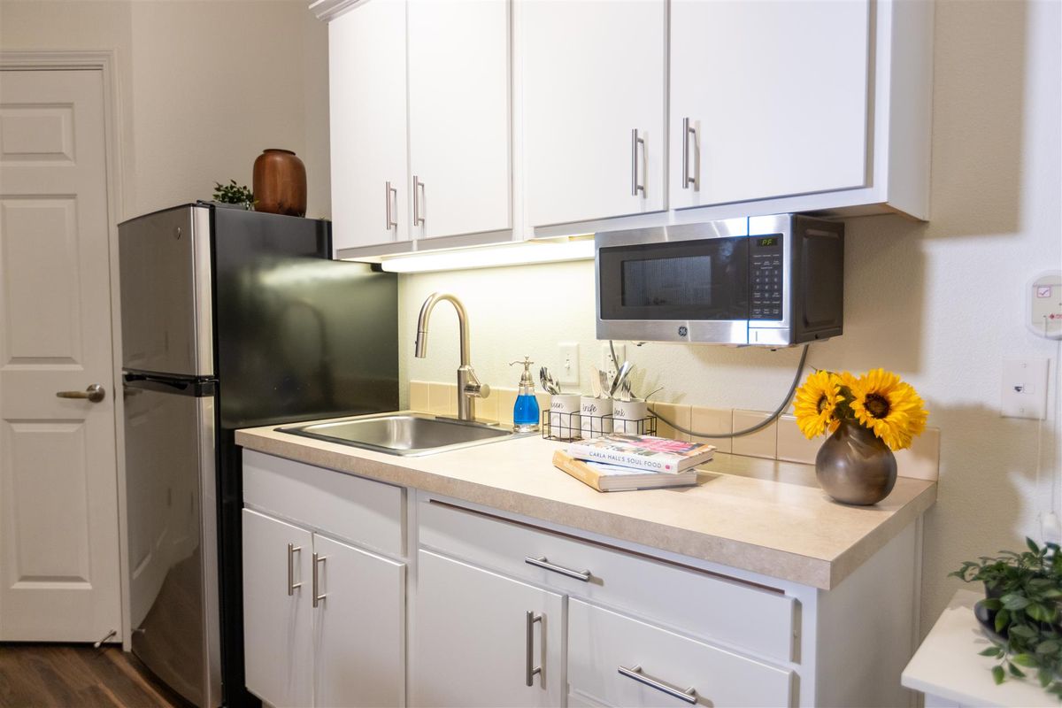 A modern kitchen with white cabinets and appliances.