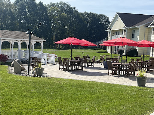 A sunny outdoor patio area featuring red umbrellas and wooden furniture, perfect for relaxation.
