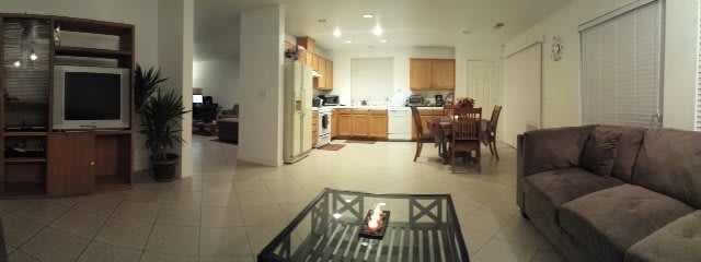 A modern kitchen and dining area with wooden cabinets and a glass coffee table.