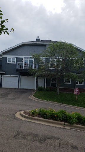 A modern residential building with garages and landscaped greenery.