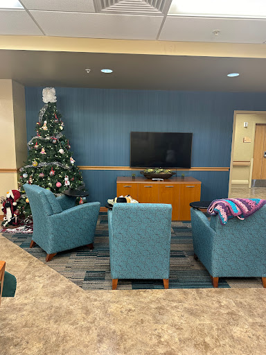 A cozy living room space decorated with a Christmas tree and comfortable seating, perfect for relaxation.