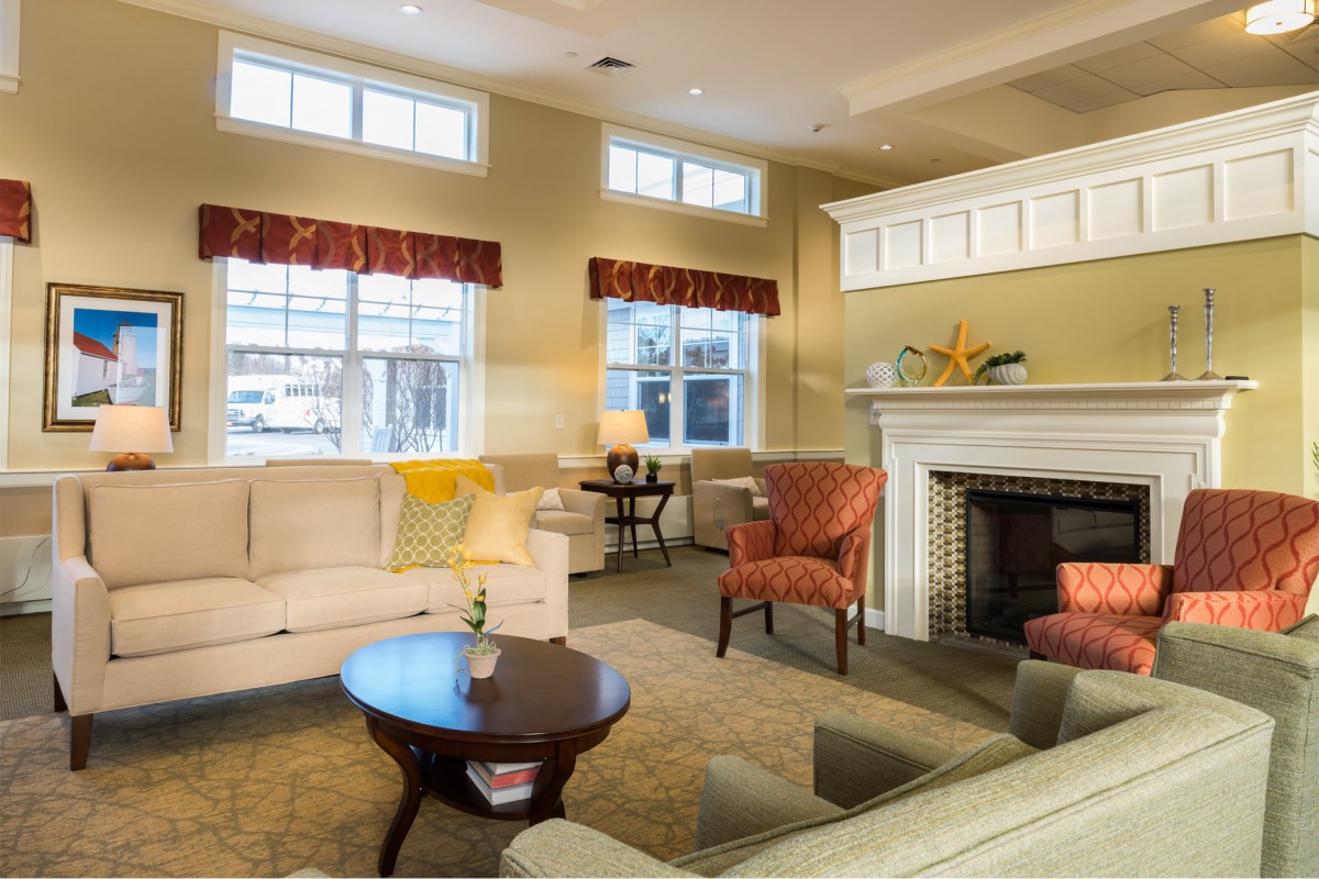 A cozy living room featuring a sofa, armchairs, and a fireplace.