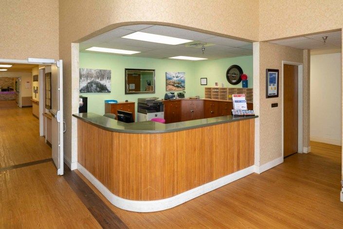 A reception area with a wooden front desk and office decor.
