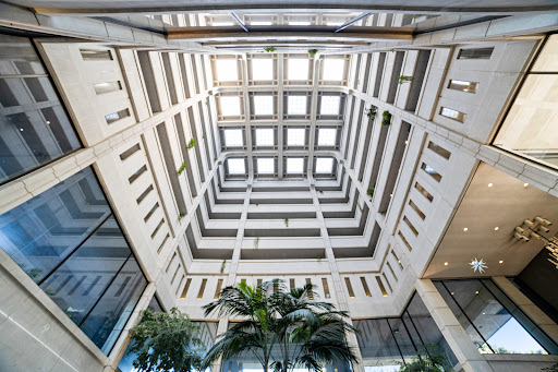 A stunning view of a modern architectural atrium, showcasing intricate ceiling designs and lush greenery.