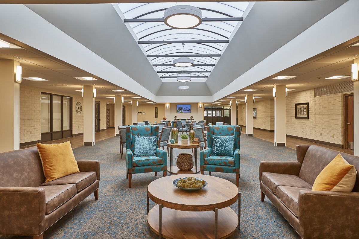 A spacious and modern lounge area with comfortable seating and a skylight ceiling.