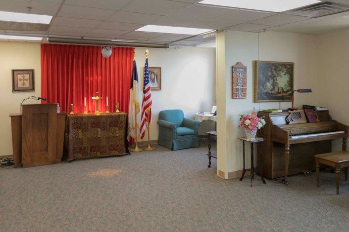 A church interior with a pulpit and flags.