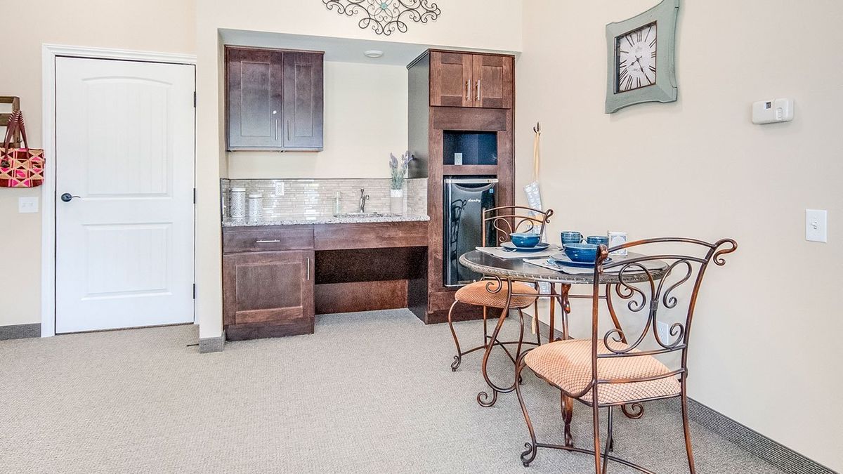 A cozy kitchen area with a dining set and wooden cabinetry.