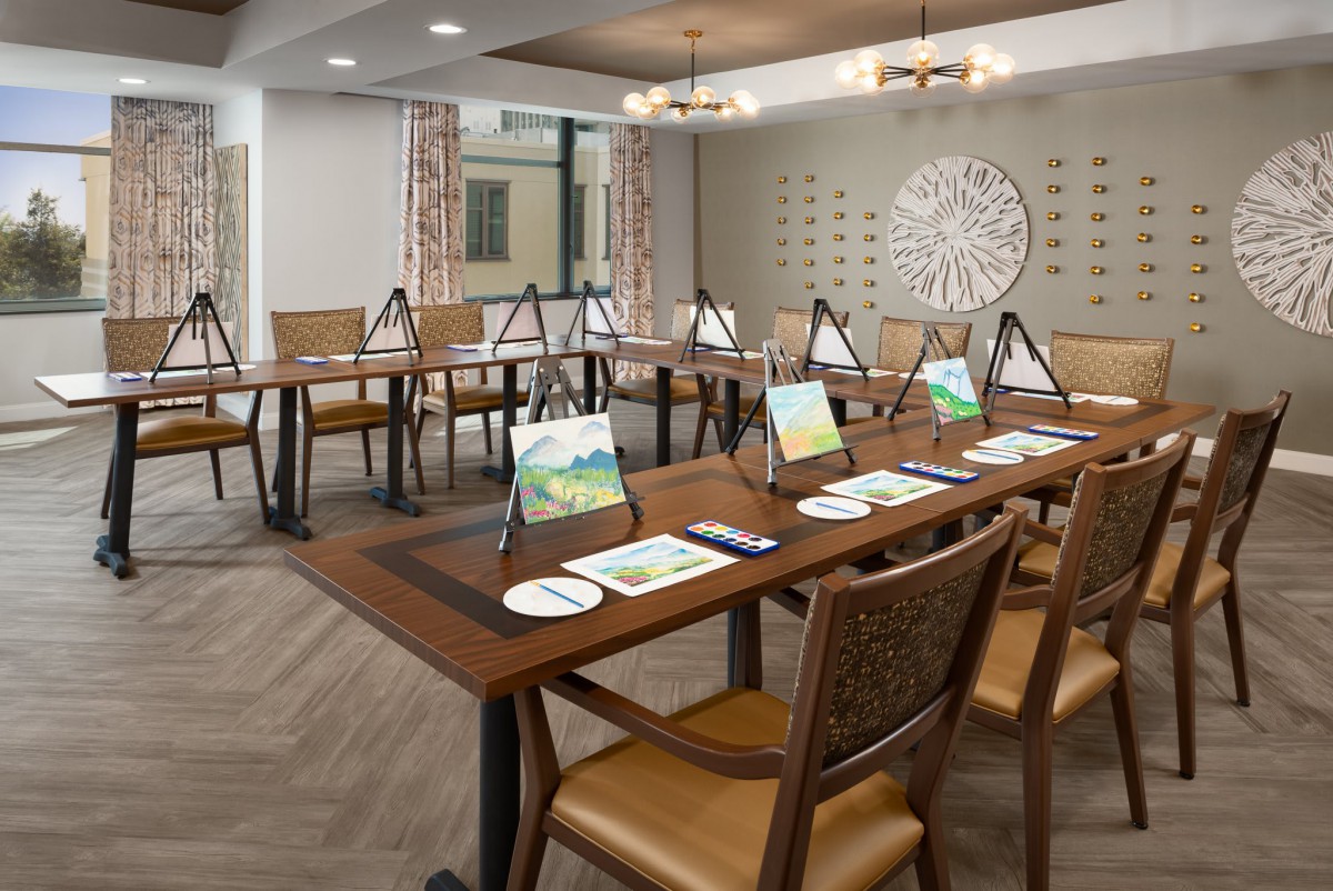 A well-organized meeting room set up with art supplies and easels for a painting session.