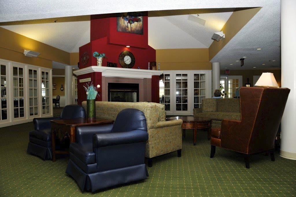 A cozy living room with comfortable seating around a central fireplace.
