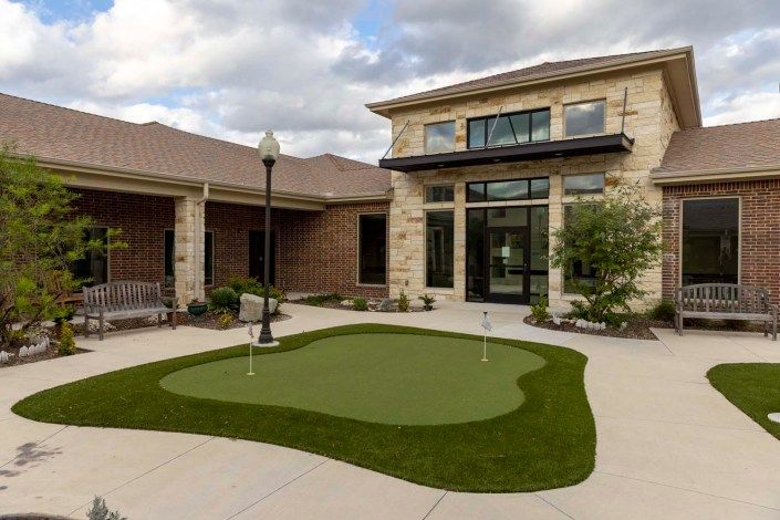 A modern building courtyard featuring a putting green.
