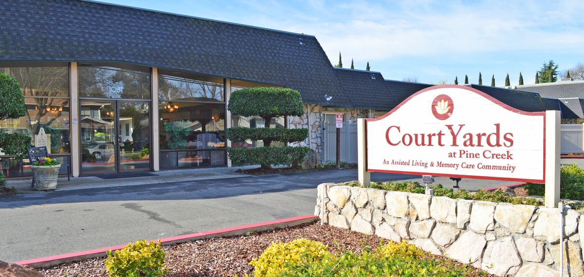 Entrance to an assisted living facility with landscaped surroundings.