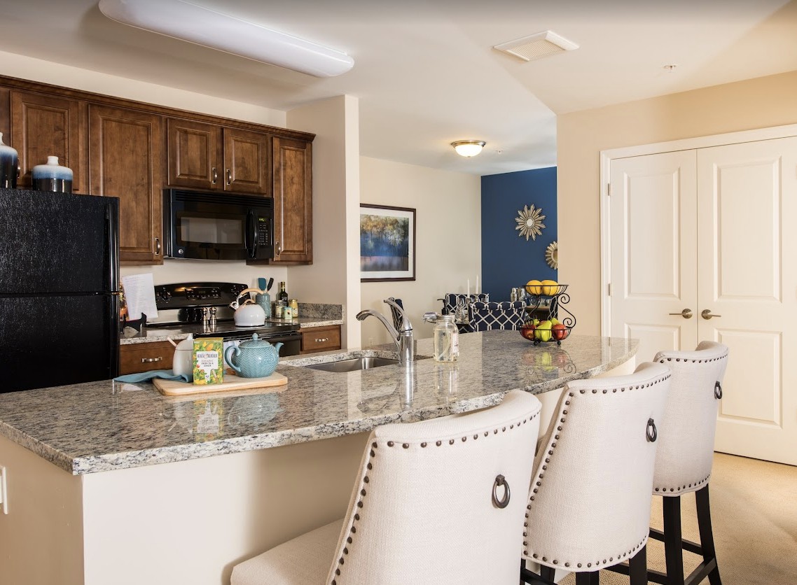 A modern kitchen with a spacious countertop and stylish chairs.