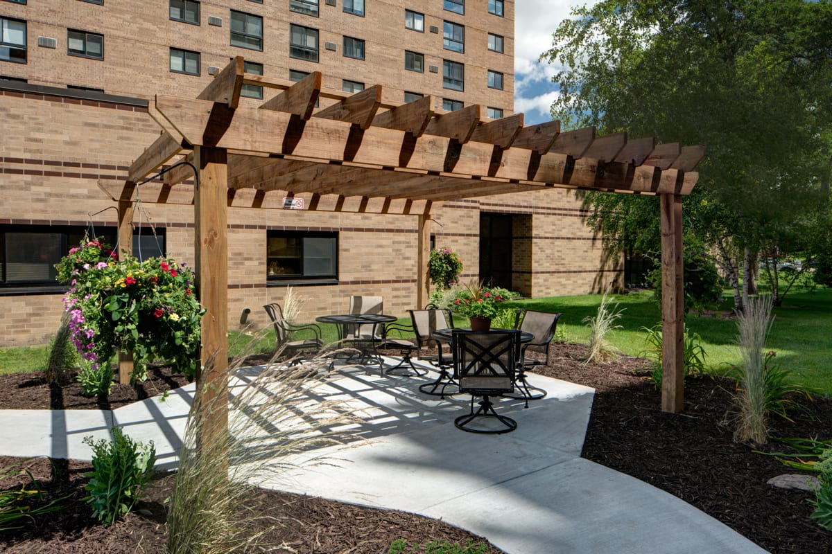 Outdoor seating area with a pergola near a building