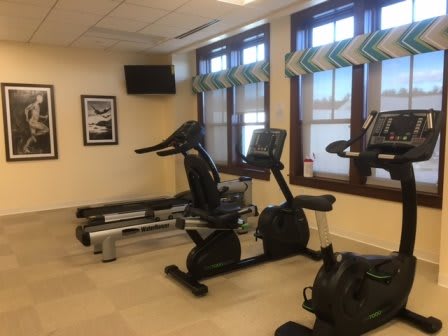 An indoor gym area with exercise equipment including treadmills and stationary bikes.