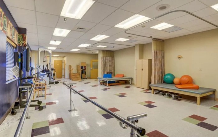 A spacious rehabilitation room equipped with physical therapy and exercise equipment.