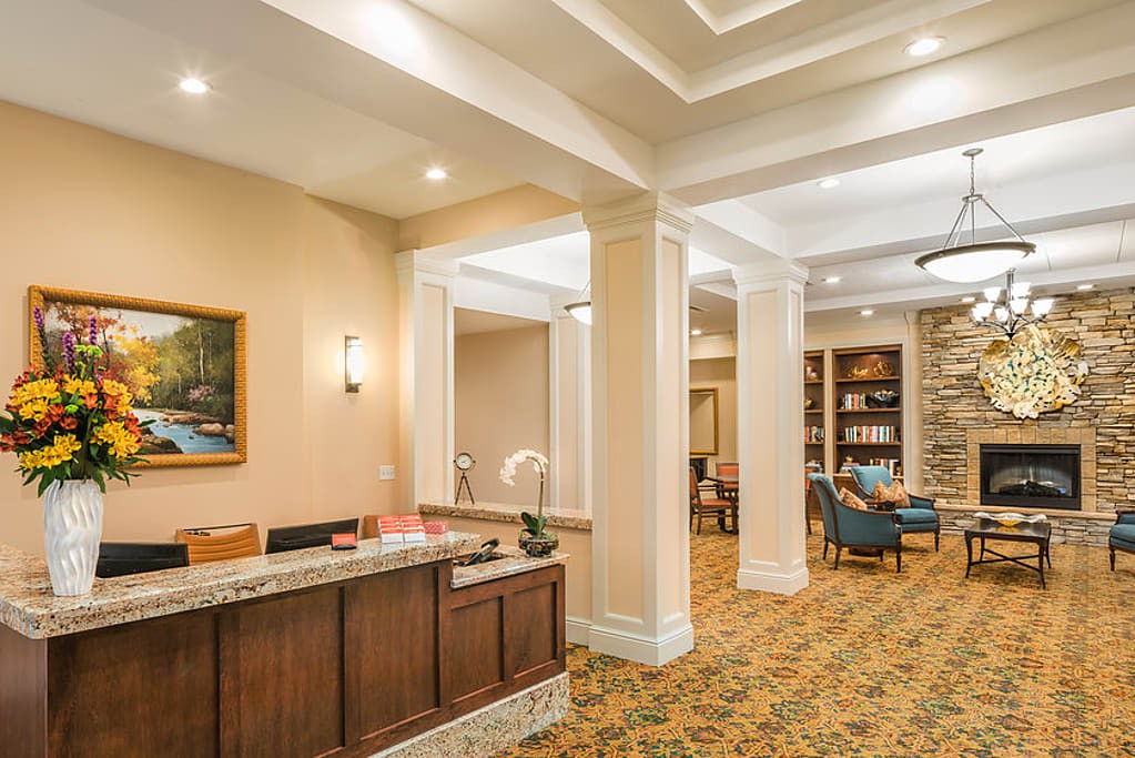 A warmly lit hotel lobby with a reception desk and comfortable seating.