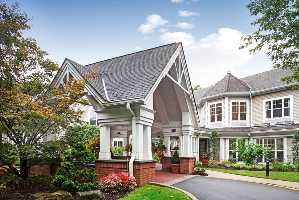 A picturesque residential house with a grand entrance and well-maintained garden.