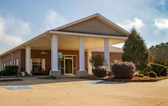 A building with a columned entrance and surrounding landscaping.