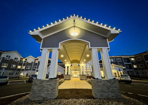 A beautifully lit entrance of a modern building at night, showcasing elegant architectural features.