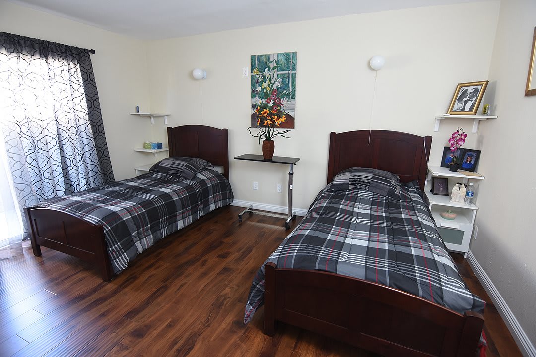A modern bedroom with twin beds and wooden flooring.