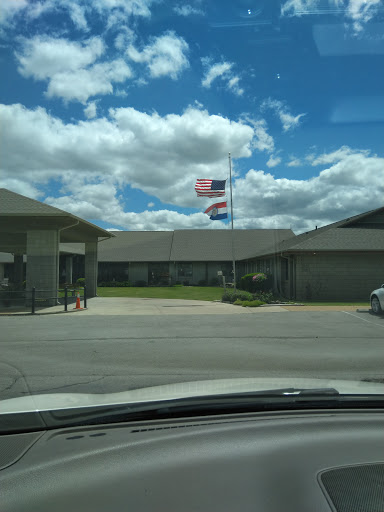 A view of a building with flags flying under a partly cloudy sky.