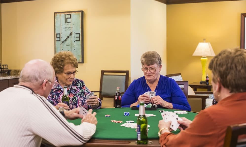 A group of seniors enjoying a card game together at a table.