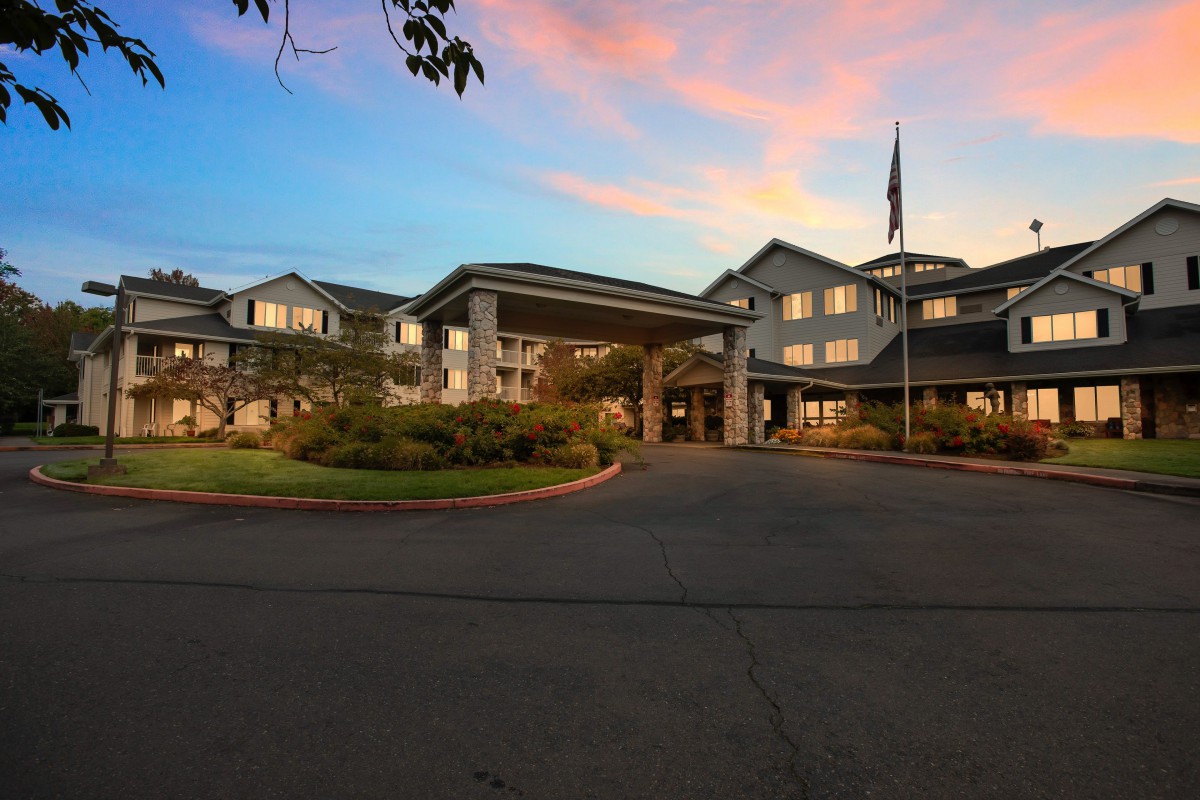 A hotel building with a grand entrance at sunset.