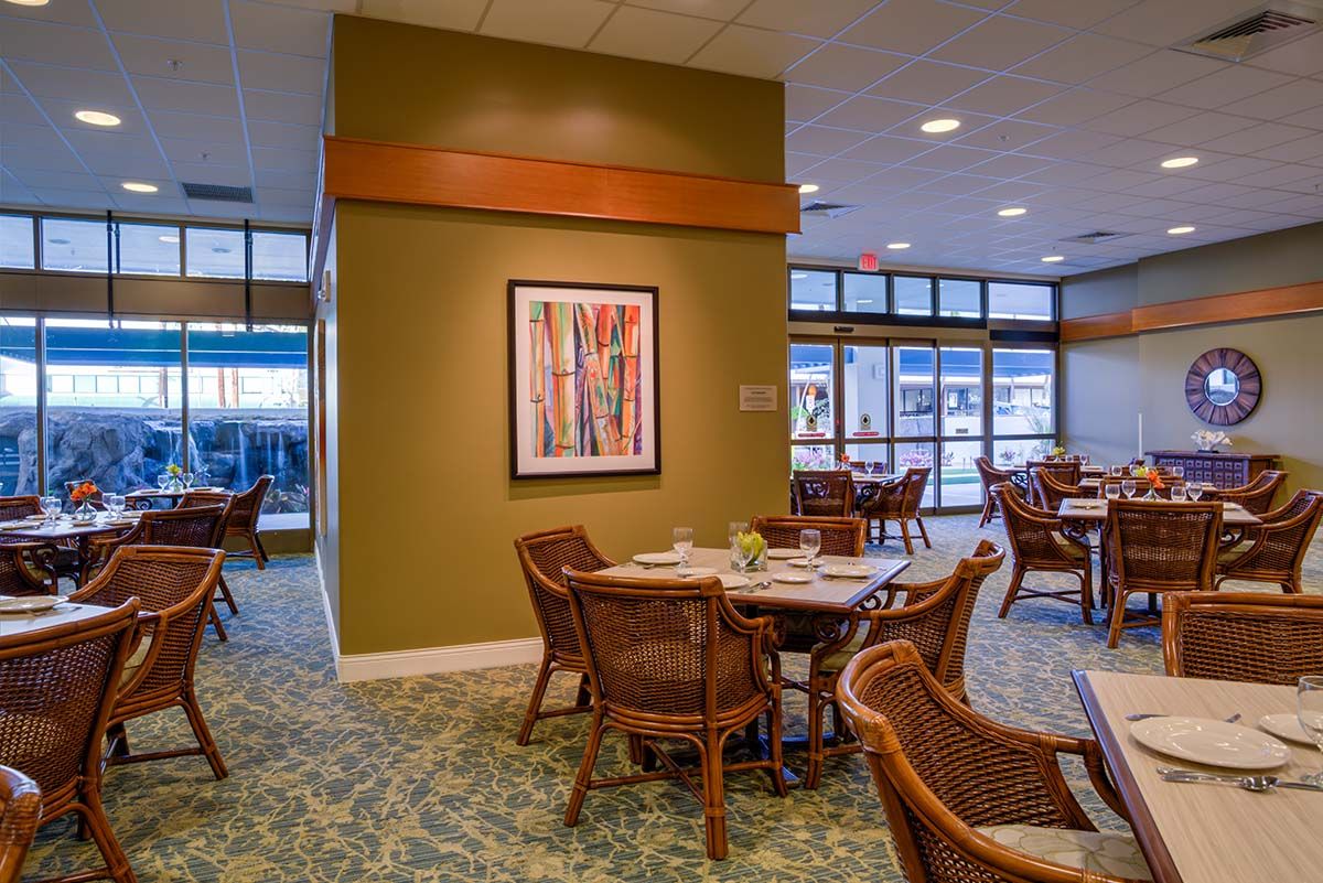 A modern dining area with stylish furniture and colorful artwork on the wall.