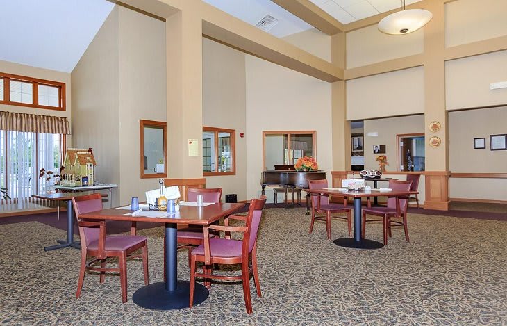 A spacious dining area with neatly arranged tables and chairs, featuring a carpeted floor and elegant interior decor.