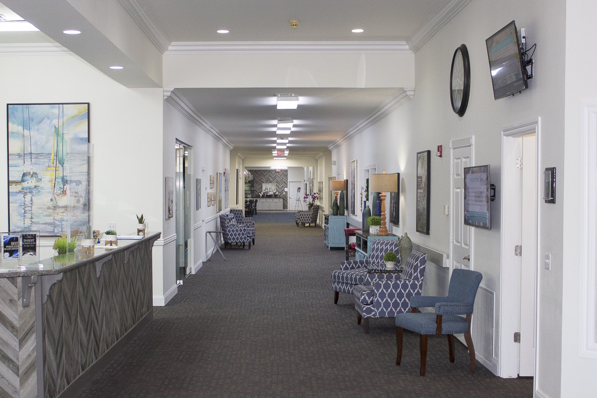 A well-lit hallway featuring comfortable seating and decorative elements.