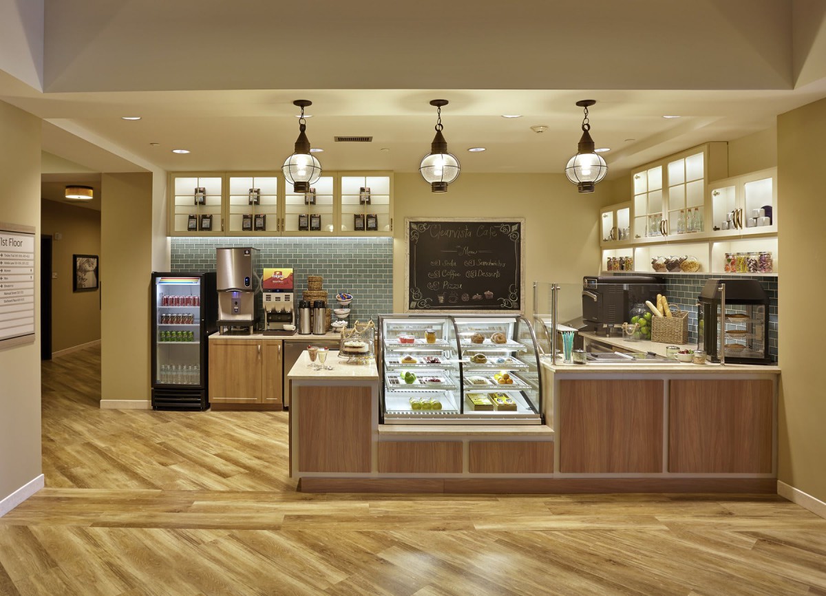 A modern cafe interior with a display counter and beverage options.