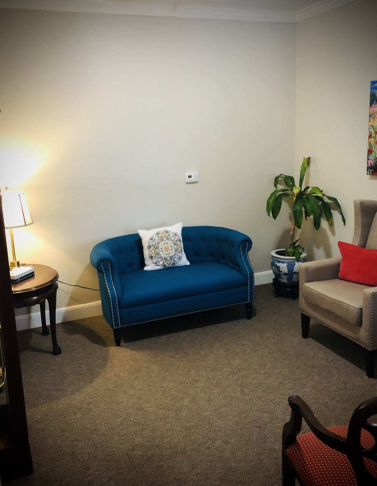 A cozy living room with a blue sofa, beige armchair, and warm lighting.