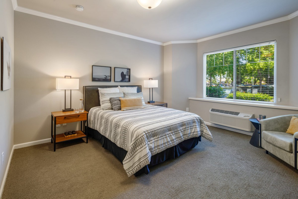 A modern bedroom with elegant decor, featuring a comfortable bed and large window.