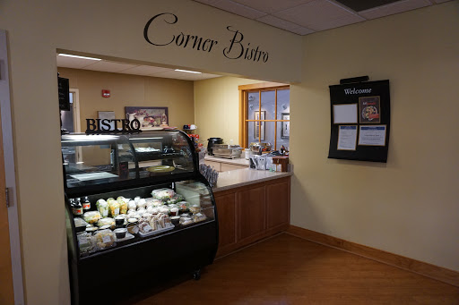A cozy corner bistro featuring a food display and a welcoming atmosphere.