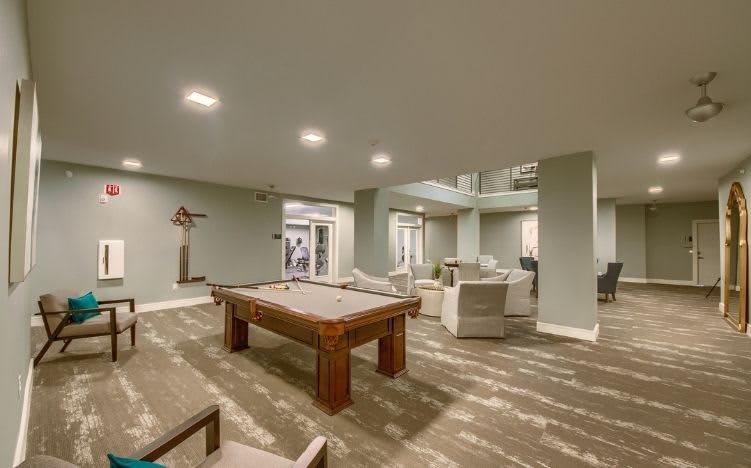 A modern recreation room featuring a pool table and comfortable seating area.
