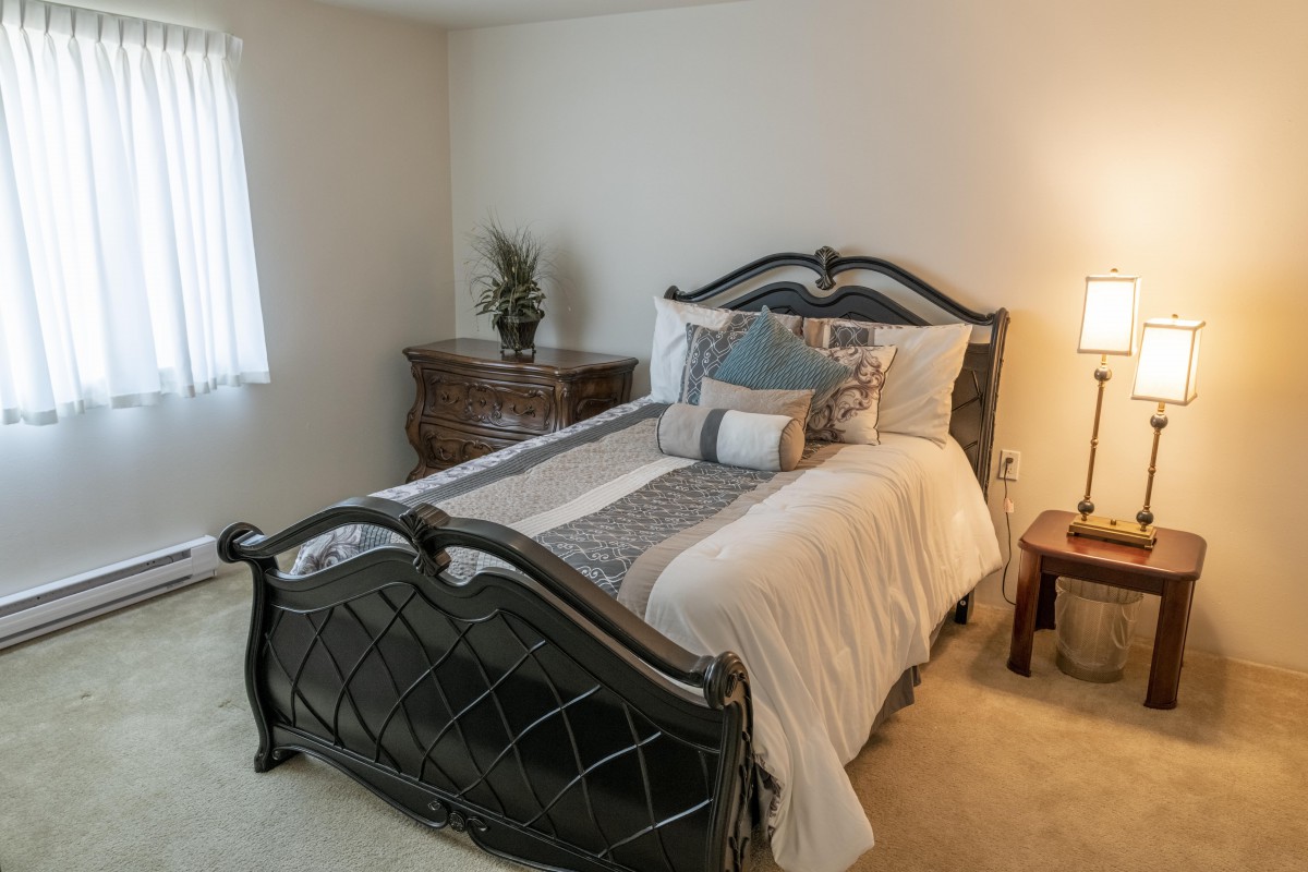 A cozy bedroom with a stylish bed and elegant furnishings.