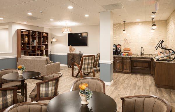 A cozy lounge area with seating, a coffee station, and a TV.