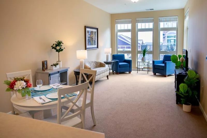 A modern living room with cozy seating and a small dining area.