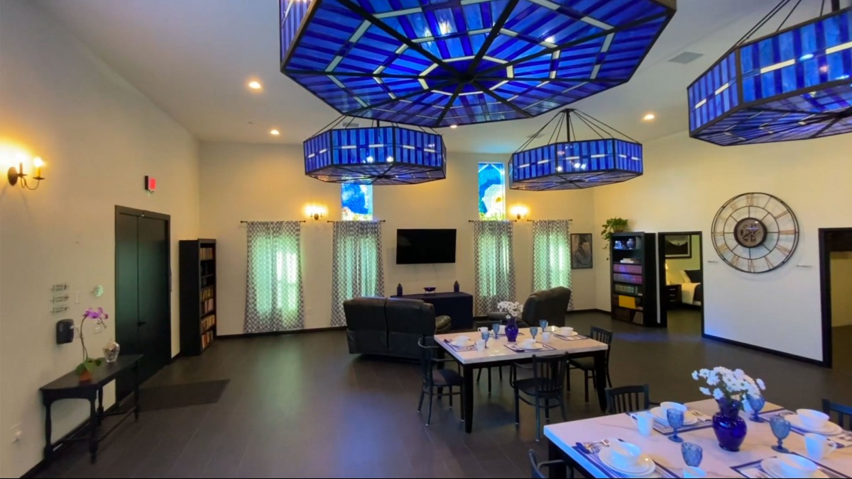 A modern room with striking blue ceiling lights and a dining area.