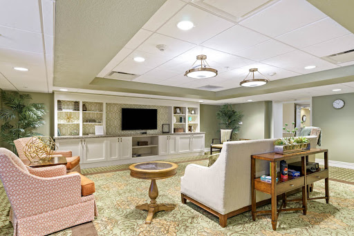 A cozy and modern lounge area featuring comfortable seating, a television, and warm lighting.